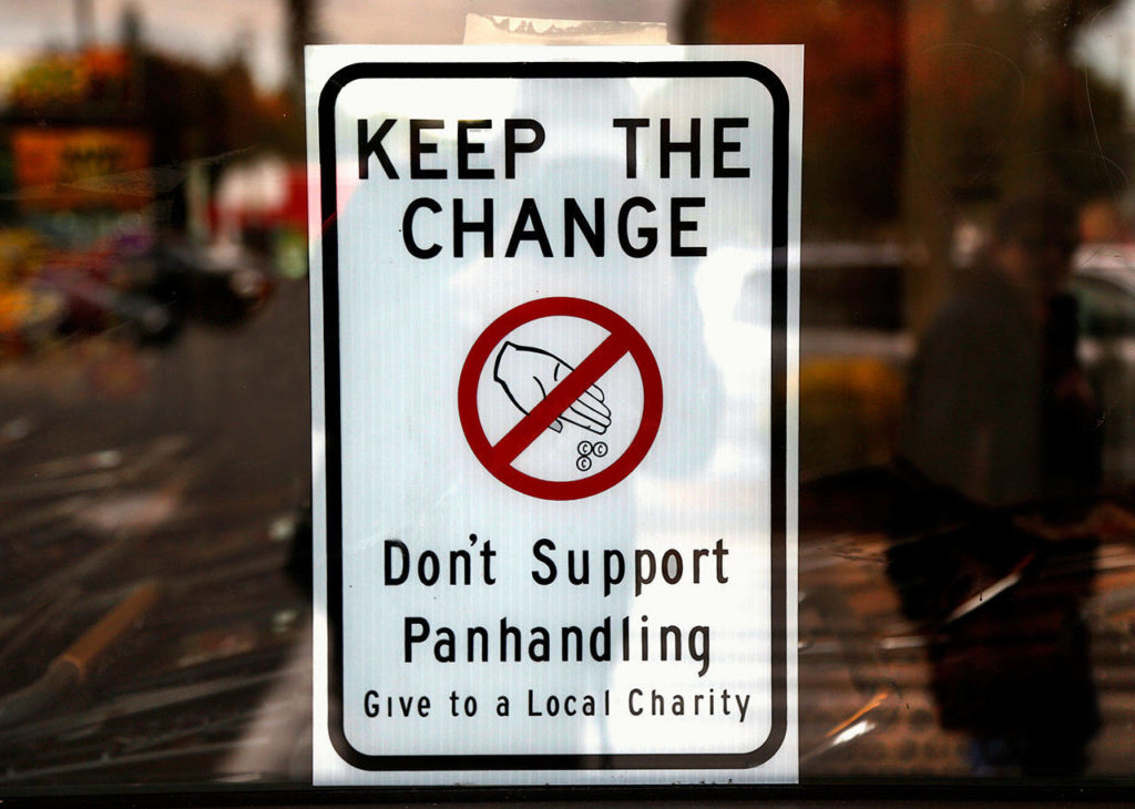 Marysville signage, visible in key locations such as the Safeway parking lot on State Avenue, suggests that people refrain from giving money to panhandlers. (Dan Bates / The Herald)
