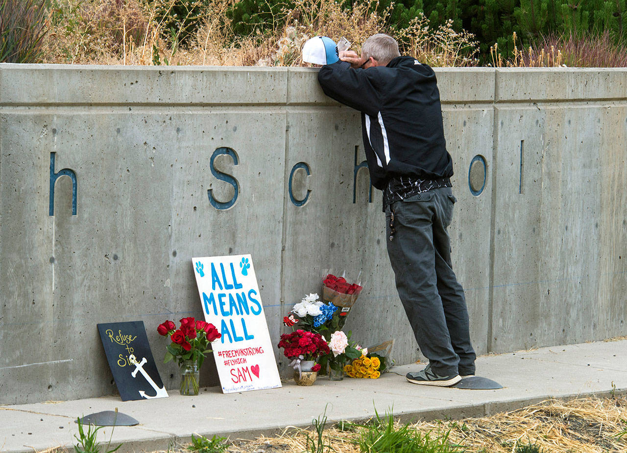 Freeman High School assistant football coach Tim Smetana grieves after placing roses at a memorial to the victims of the Sept. 13 shooting at the Eastern Washington school. “This is home” said Smetana. (Dan Pelle/The Spokesman-Review)