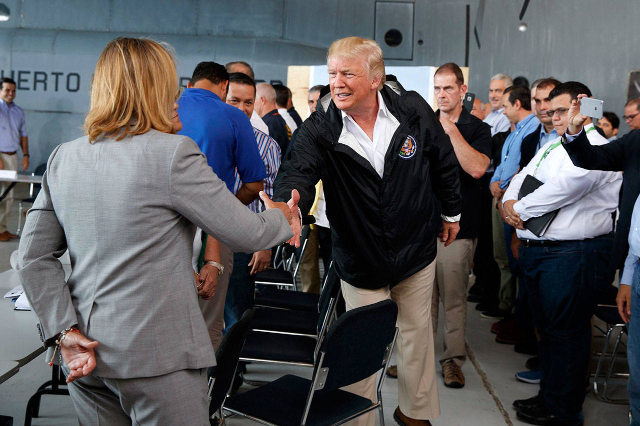 President Donald Trump shakes hands with San Juan Mayor Carmen Yulin Cruz during a briefing on hurricane recovery efforts with first responders at Luis Muniz Air National Guard Base on Tuesday in San Juan, Puerto Rico. (AP Photo/Evan Vucci)
