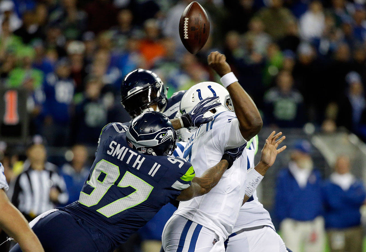 Seahawks defensive end Marcus Smith (97) forces a fumble from Colts quarterback Jacoby Brissett in the second half of a game on Oct. 1, 2017, in Seattle. (AP Photo/Elaine Thompson)