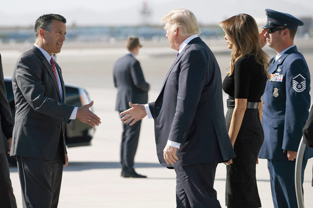 Nevada Gov. Brian Sandoval (left) greets President Donald Trump and first lady Melania Trump as they arrive Wednesday at Las Vegas McCarran International Airport to meet with victims and first responders of the mass shooting. (AP Photo/Evan Vucci)
