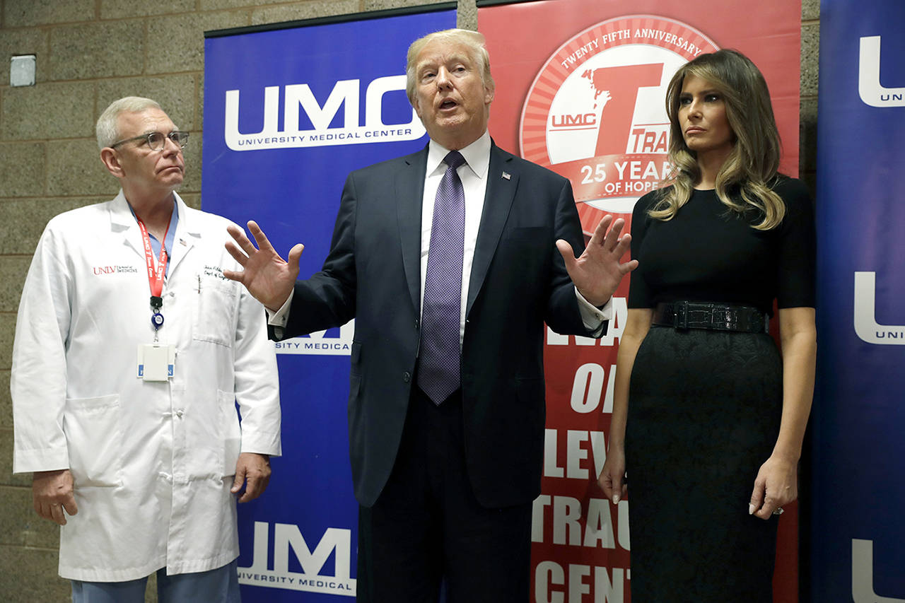 President Donald Trump talks as first lady Melania Trump and surgeon Dr. John Fildes listen at the University Medical Center after Trump met with survivors of the mass shooting Wednesday in Las Vegas. (AP Photo/Evan Vucci)