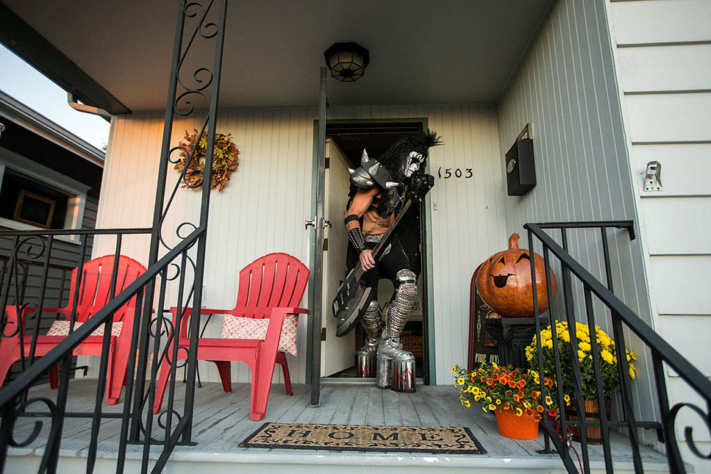 Dressed up as Gene Simmons, of KISS fame, Everett paramedic Jack Murrin bends down low to get out his front door and head out to a open mic session at Cafe Zippy on Oct. 5 in Everett. (Andy Bronson / The Herald)
