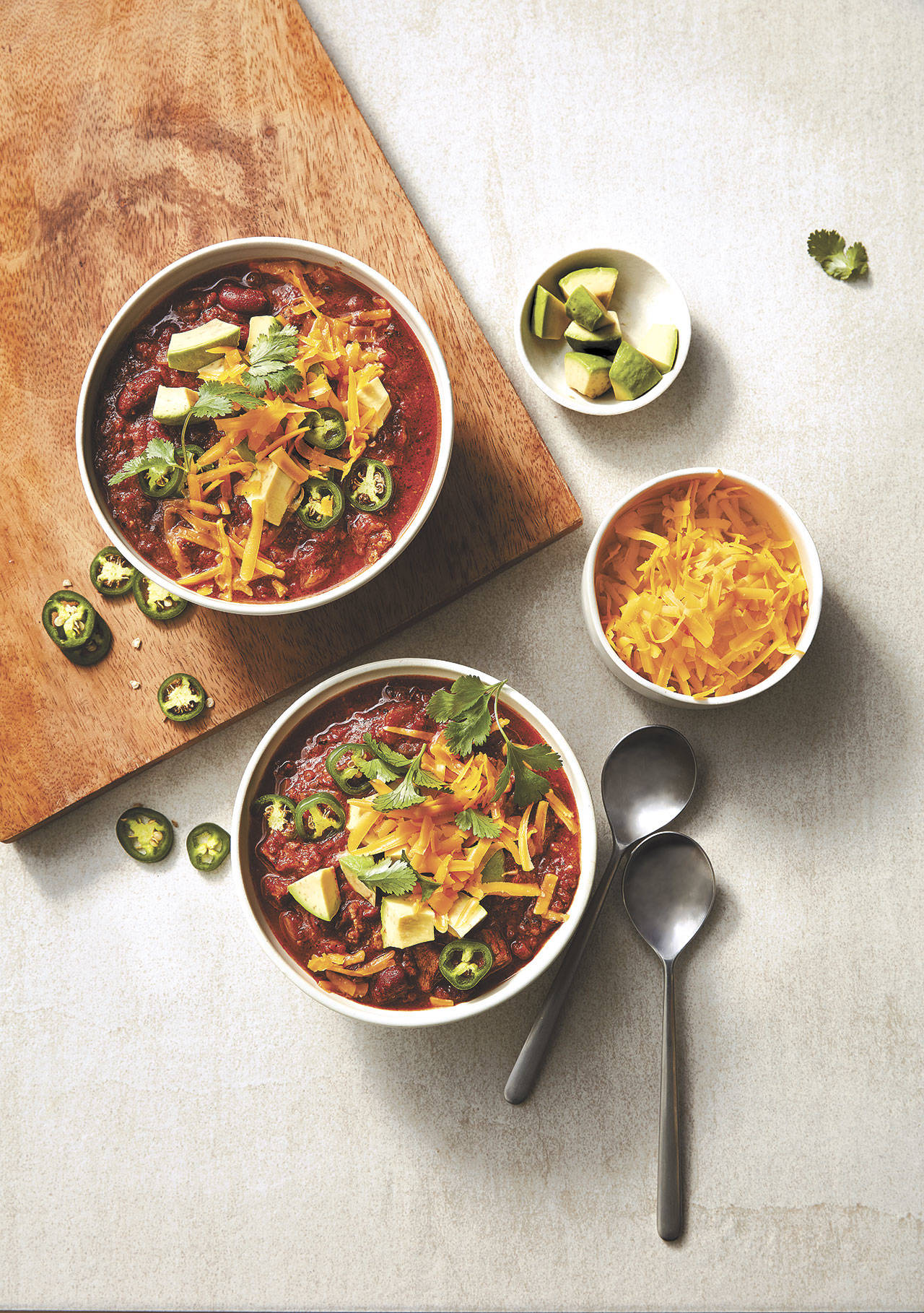 Serve slow cooker beef and bean chili topped with avocado, jalapeno slices, shredded cheddar and cilantro. (Greg Dupree)