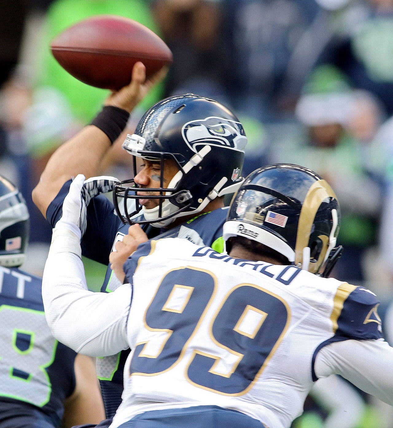 The Rams’ Aaron Donald hits Seahawks quarterback Russell Wilson as he throws during a game on Dec. 28, 2014, in Seattle. (Kevin Clark / The Herald)