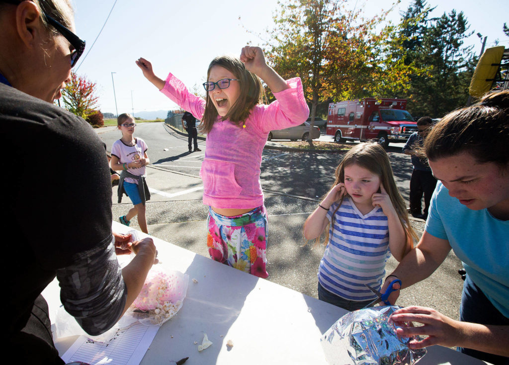 Ruby Carlson plugs her ears as Dutch Hill Elementary third grader Moriah Landry screams in joy after discovering her egg unbroken after surviving a a 70-foot drop from the top of a ladder truck on Thursday, Oct. 5, 2017 in Snohomish, Wa. (Andy Bronson / The Herald)
