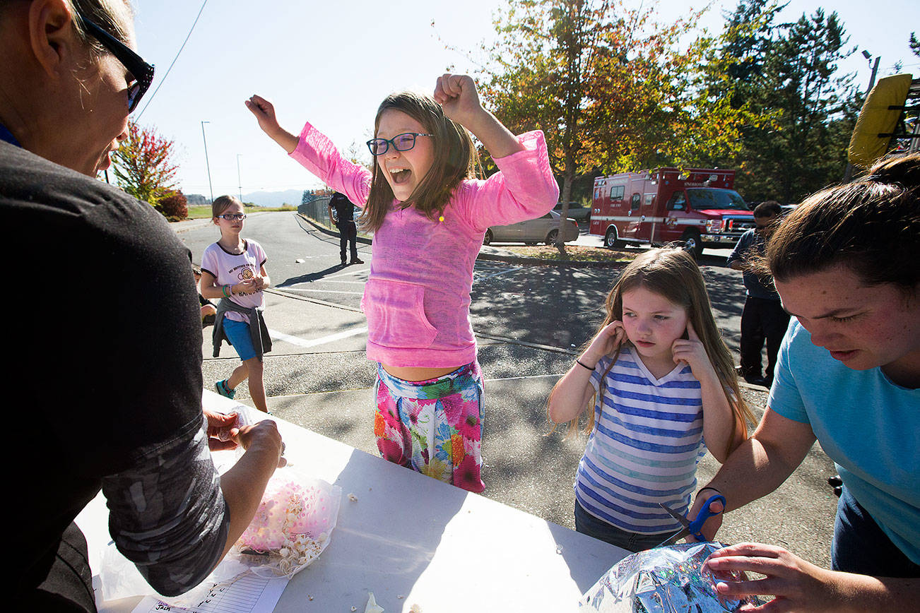 Ruby Carlson plugs her ears as Dutch Hill Elementary third-grader Moriah Landry screams in joy after discovering her egg unbroken after surviving a 70-foot drop from the top of a ladder truck Thursday in Snohomish. (Andy Bronson / The Herald)