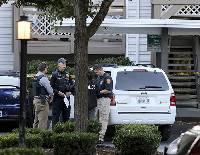 Members of the Everett Police Department confer at Walden Apartments, the scene of a shooting, in Everett on Oct. 4. (Kevin Clark / The Herald)