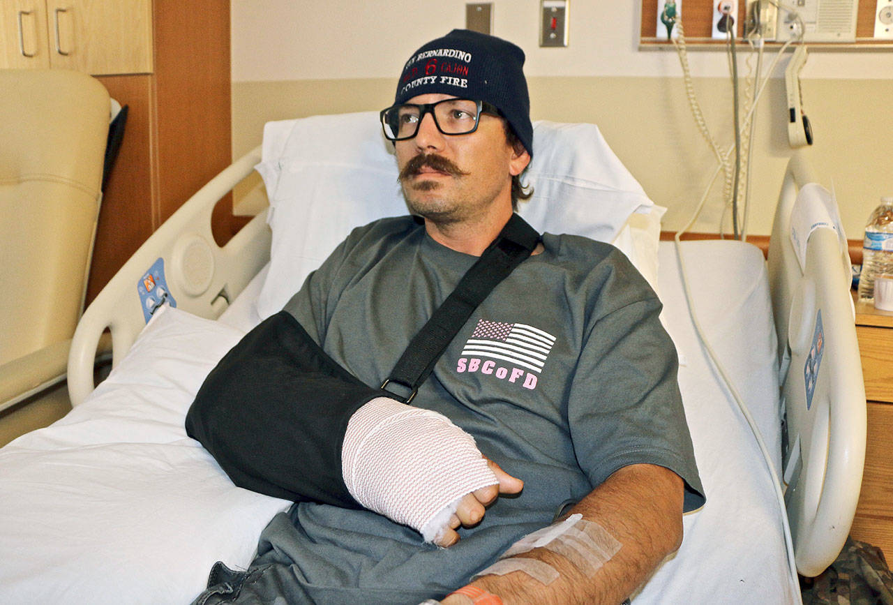 Mike Kordich, a firefighter from Rancho Cucamonga, California, answers questions from his hospital bed Tuesday at Sunrise Hospital in Las Vegas. Kordich was giving a severely injured person CPR when he was hit by a bullet after a gunman opened fire on an outdoor music concert on Sunday. (AP Photo/Robert Ray, File)