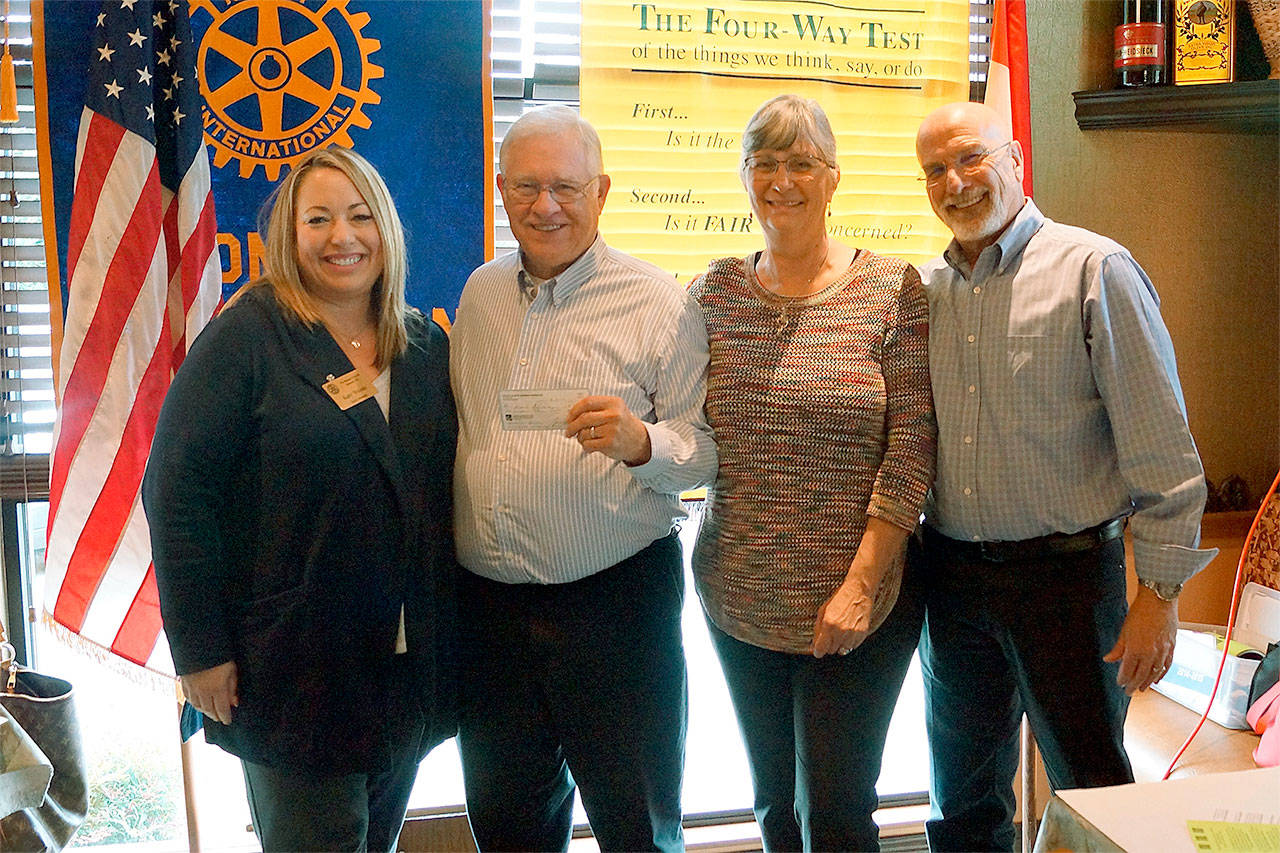 Monroe Rotary Club President Katy Woods (from left) presents Peter Kinch and Marge and Duane Fairweather with a donation of $500 for the Hands for Peacemaking Foundation. (Contributed photo)