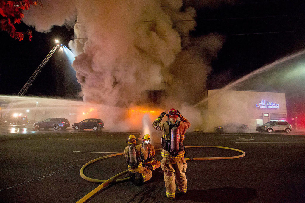 Firefighters add another hose to the three-alarm fire at Everett Office Furniture on Broadway on Sept. 25 in Everett. (Andy Bronson / Herald file)
