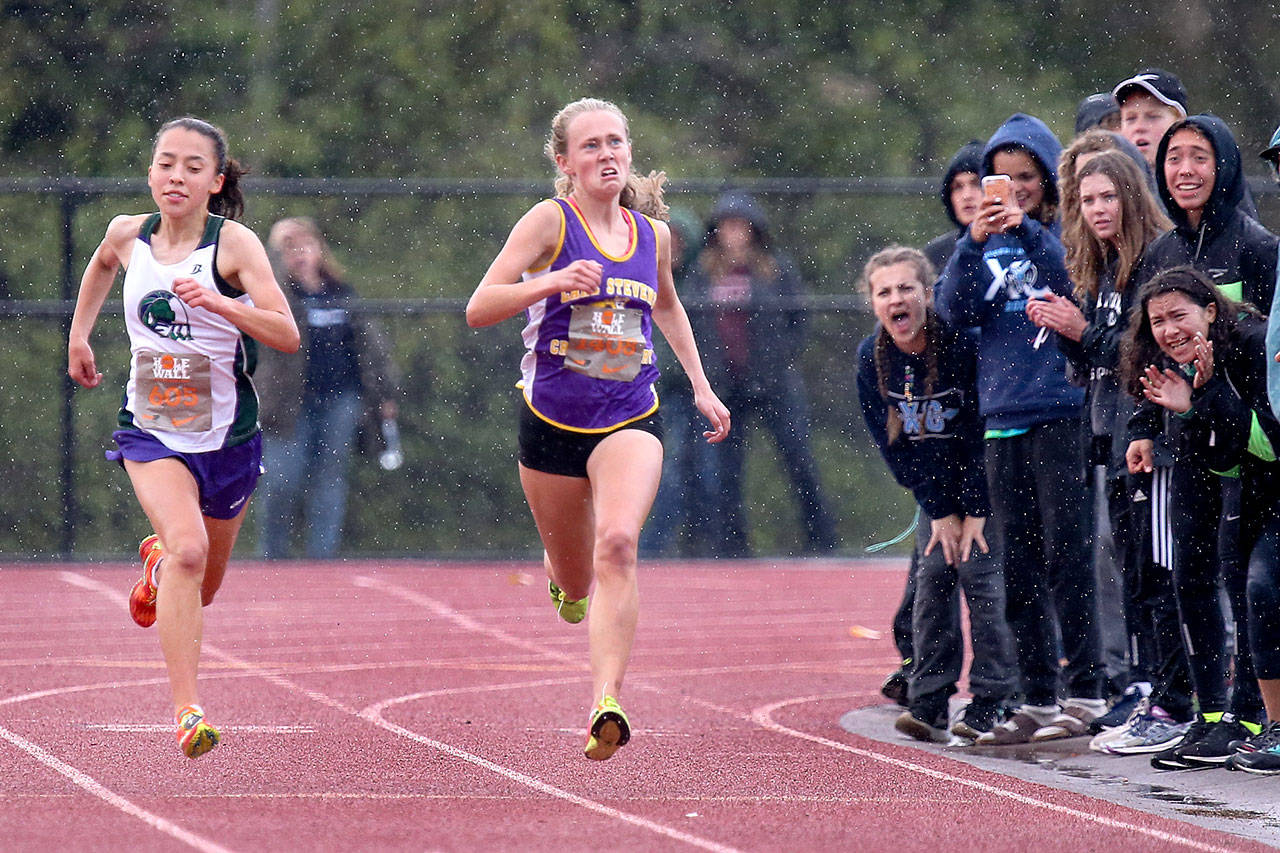Edmonds-Woodway’s Yukino Parle (left) edges out Lake Stevens’ Taylor Roe for a first-place finish during the 34th annual Hole in the Wall Cross Country Invitational on Oct. 7, 2017, at Lakewood High School in Arlington. (Kevin Clark / The Herald)
