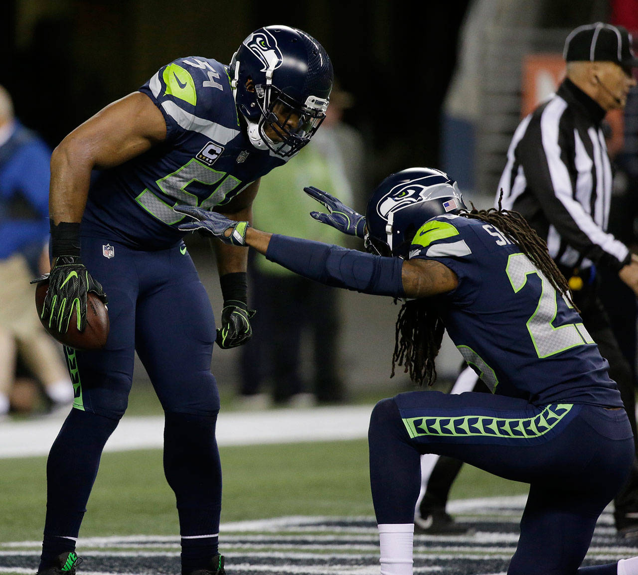 Seahawks cornerback Richard Sherman (right) bows before middle linebacker Bobby Wagner after Wagner recovered a fumble for a touchdown against the Colts on Oct. 1, 2017, in Seattle. (AP Photo/Elaine Thompson)