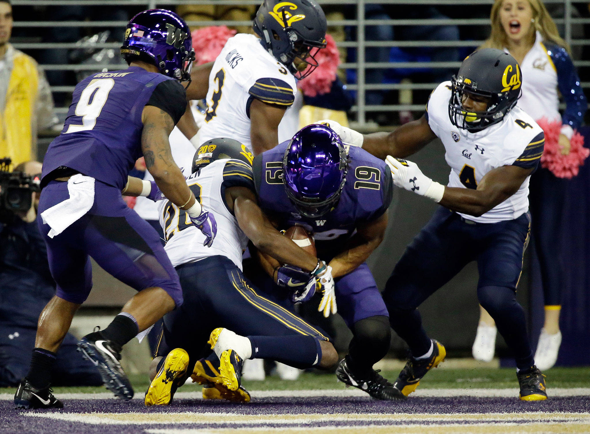 Washington’s Hunter Bryant (19) comes down with the catch in a crowd to score against California in the first half of a game Oct. 7, 2017, in Seattle. (AP Photo/Elaine Thompson)