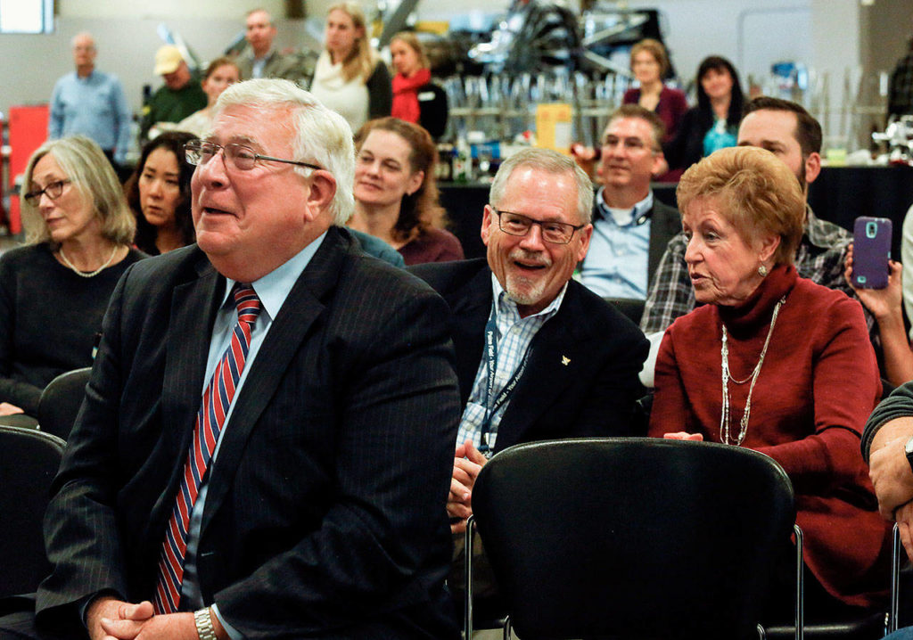 Former Snohomish County Executive Bob Drewel (left foreground), Bill Loomis and Vi Stockman listen and react to a speech by Rick Lengyel during the EvCC Aviation Maintenance Technology School’s 50-year anniversay celebration Wednesday at Paine Field. (Dan Bates / The Herald)
