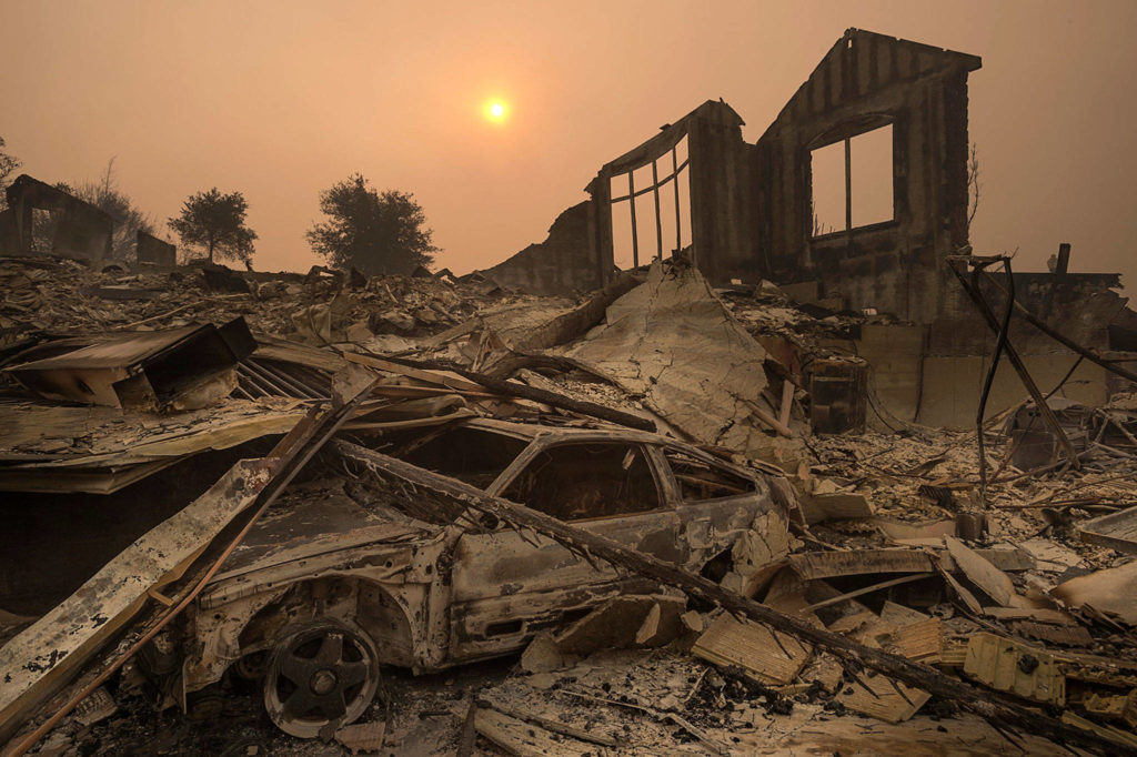 The sun rises through a cloud of smoke on Tuesday in Santa Rosa, California, after a wildfire swept through. (Paul Kitagaki Jr. /The Sacramento Bee via AP)
