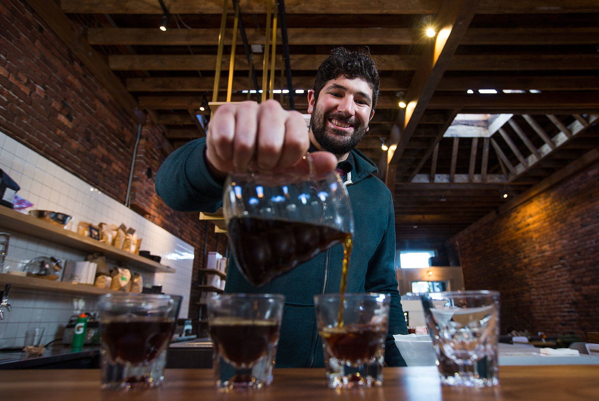 Barista Ryan Bisson pours one of the brews from Bean Box and reviews each while at Narrative Coffee on Oct. 3 in Everett. (Andy Bronson / The Herald)