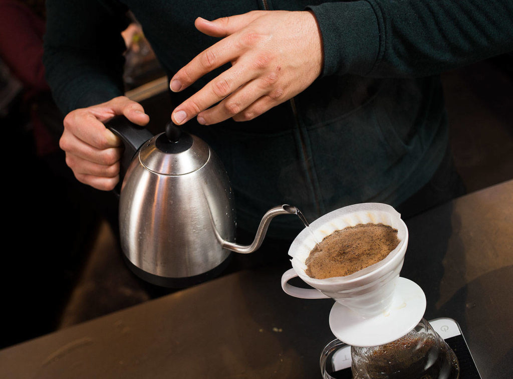 Making circles as he pours, Barista Ryan Bisson brews up one of four coffees from Bean Box and reviews each while at Narrative Coffee on Oct. 3 in Everett. (Andy Bronson / The Herald)
