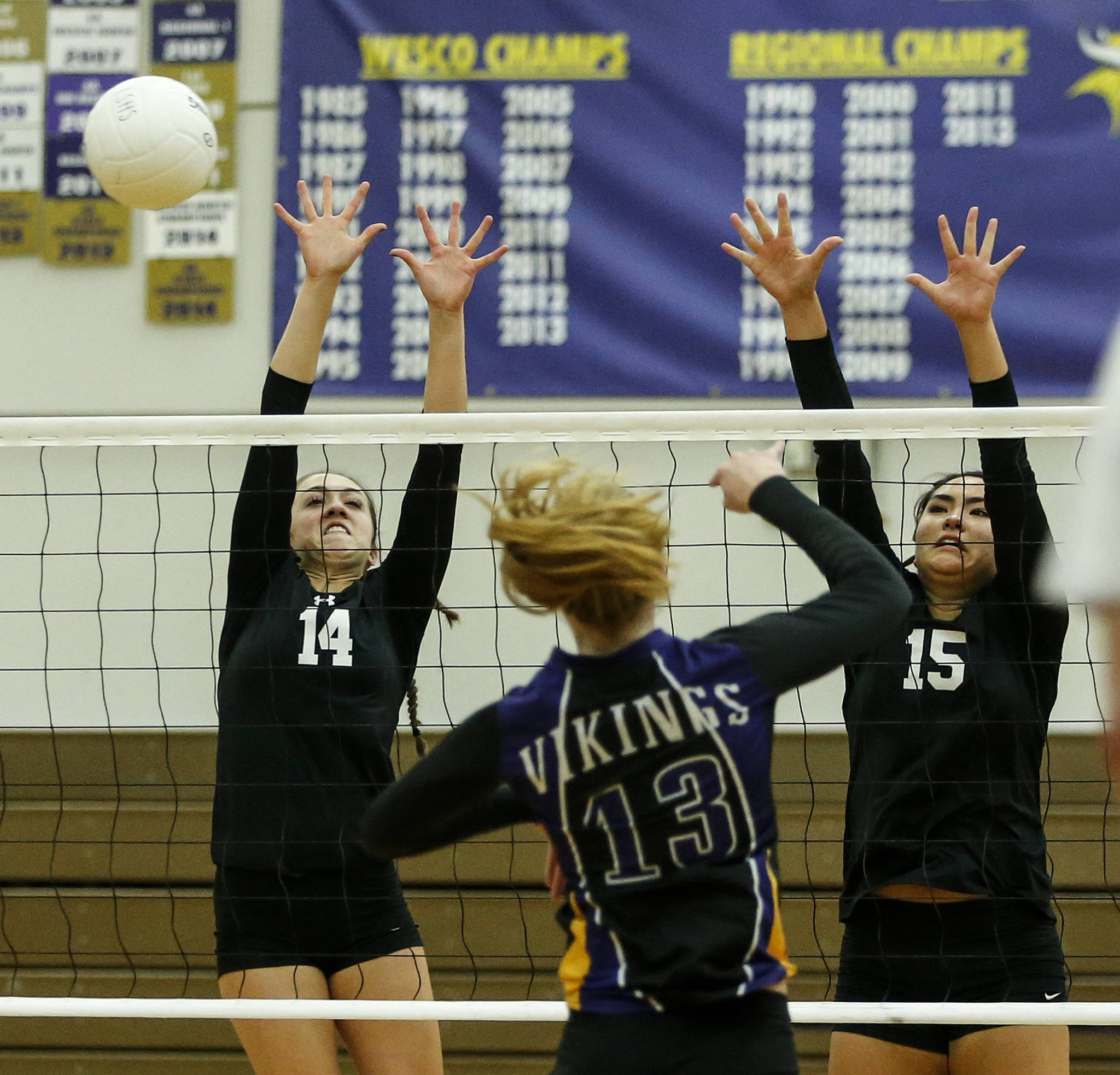 Kamiak’s Grace Forster (14) and Jaclyn Janczakowski (15) go up for a block against Lake Stevens’ Hayley Muir (13) during a game on Oct. 10, 2017, at Lake Stevens High School. (Ian Terry / The Herald)