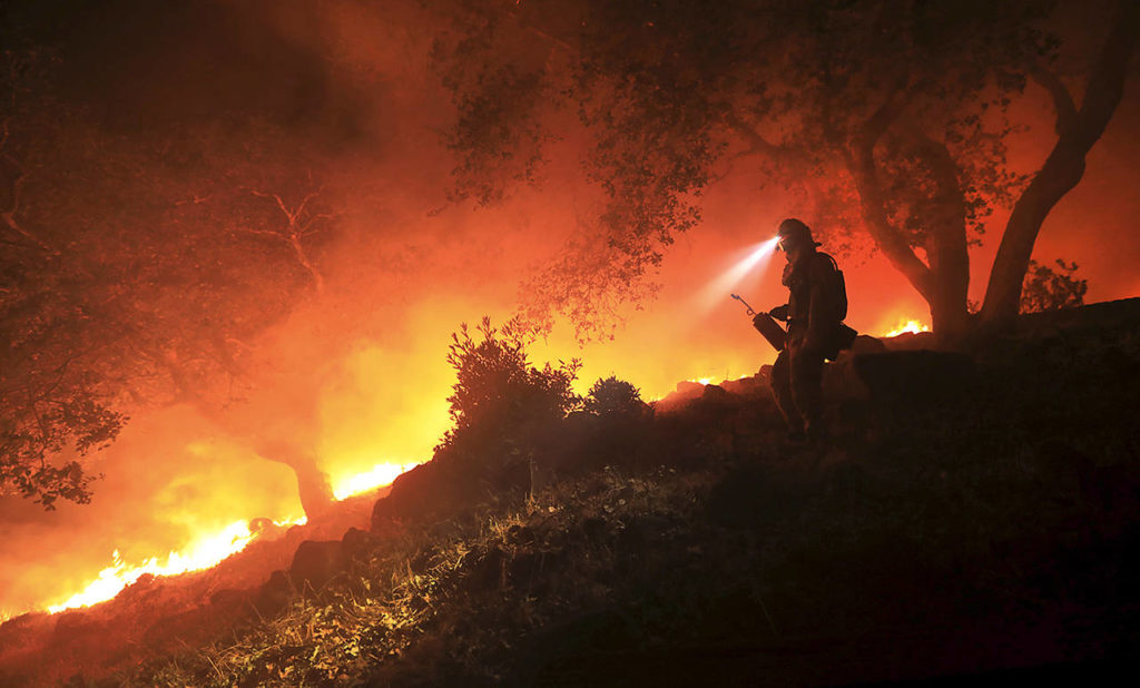 A San Diego Cal Fire firefighter monitors a flare up on a the head of a wildfire (the Southern LNU Complex), off of High Road above the Sonoma Valley on Wednesday in Sonoma, California. (Kent Porter/The Press Democrat via AP)
