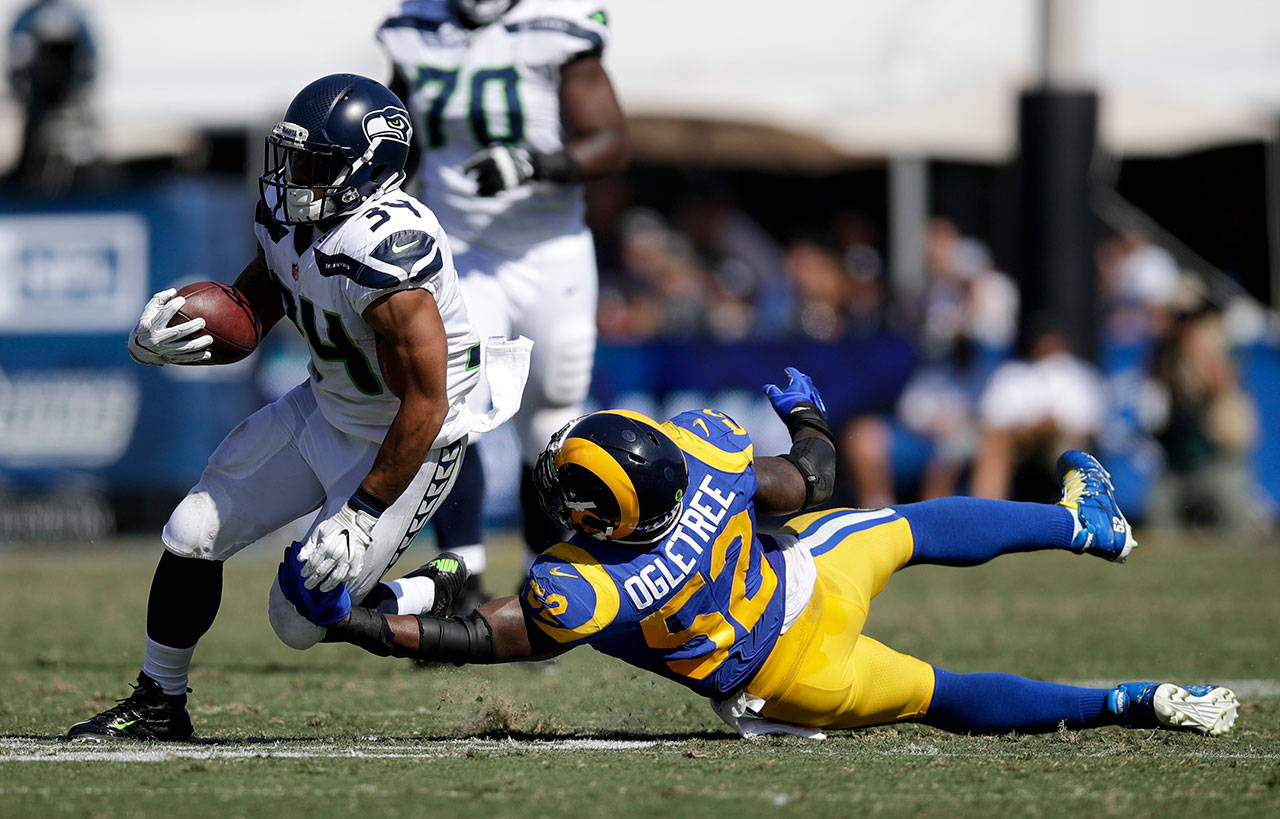 Seahawks running back Thomas Rawls (left) breaks away form Rams inside linebacker Alec Ogletree during the first half of a game Oct. 8, 2017, in Los Angeles. (AP Photo/Jae C. Hong)