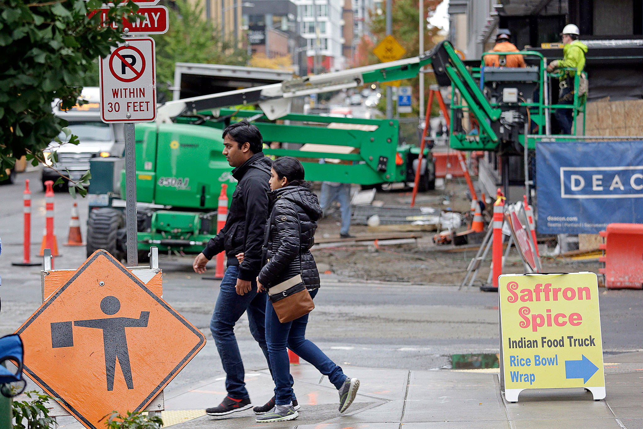 Pedestrians walk past a construction site near Amazon’s South Lake Union headquarters in Seattle. (AP Photo/Elaine Thompson)