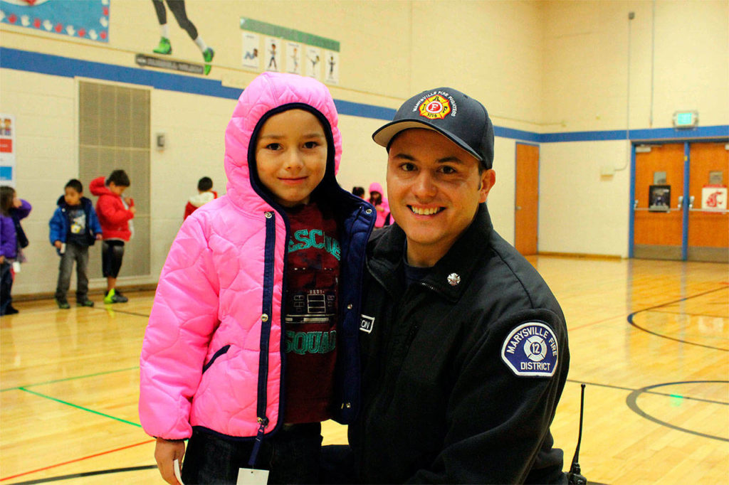More than 80 local children received brand new winter coats today thanks to Marysville Professional Firefighters, IAFF Local 3219. Here, firefighter Ricky Williamson poses for a photo with first-grader Cristian Salazar Nitschke. (Contributed photo)
