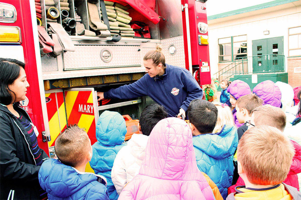 Marysville firefighter Kaitlan Hereth shows local students some of the tools in a fire engine. (Contributed photo)
