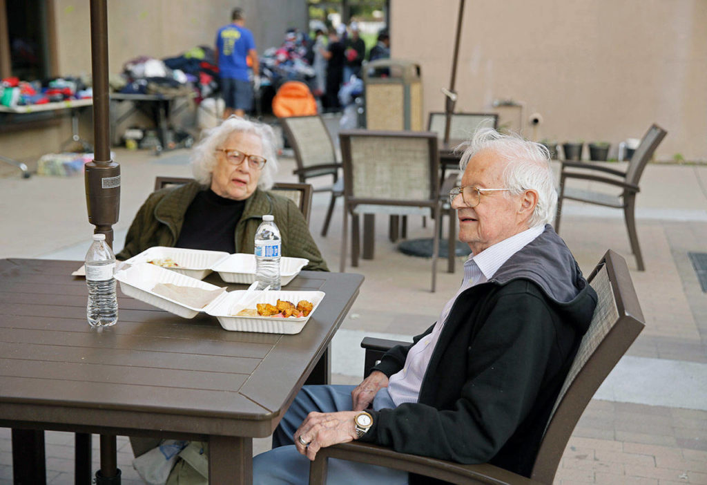 In this Oct. 11 photo, wildfire evacuees Jim Merriman (right) and his wife, Lu, have a meal while spending the evening at a Red Cross disaster relief center in Santa Rosa, California. (AP Photo/Eric Risberg, File)
