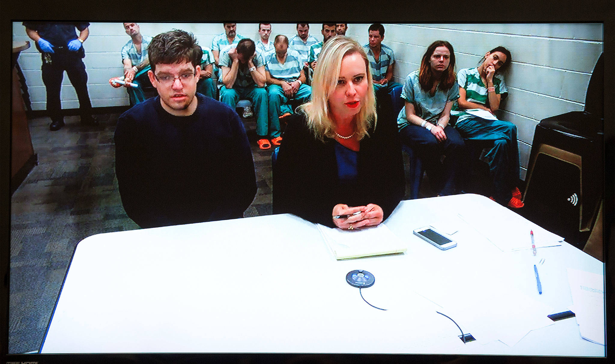 Seen on a video monitor, Rachel Forde (right), attorney for Andrew Henckel (left), speaks to the judge during a court appearance Wednesday in Everett. (Andy Bronson / The Herald)