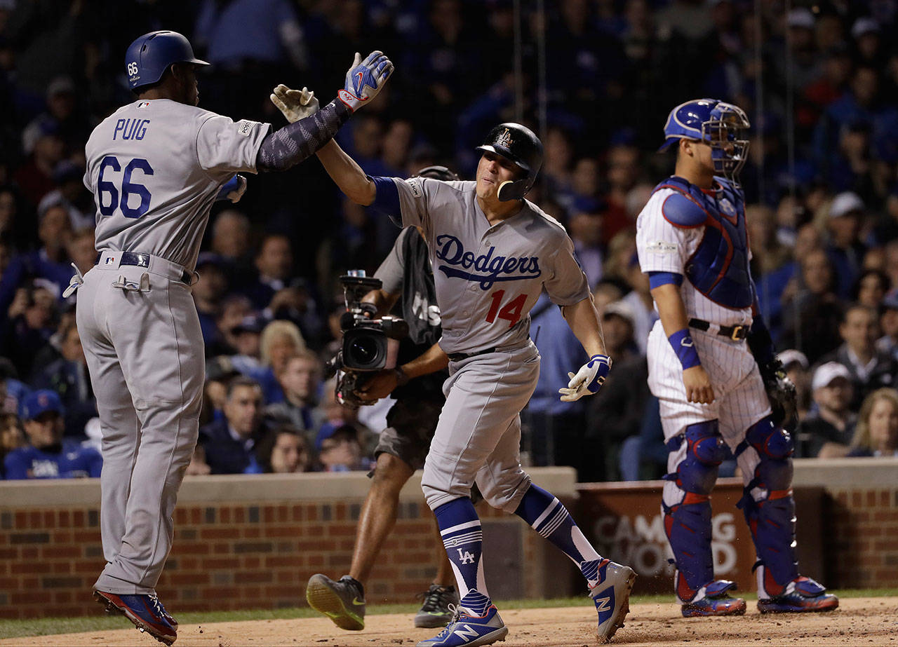 The Dodgers’ Enrique Hernandez (14) celebrates his grand slam with Yasiel Puig (66) during the third inning of Game 5 the National League Championship Series against the Cubs on Oct. 19, 2017, in Chicago. (AP Photo/Matt Slocum)