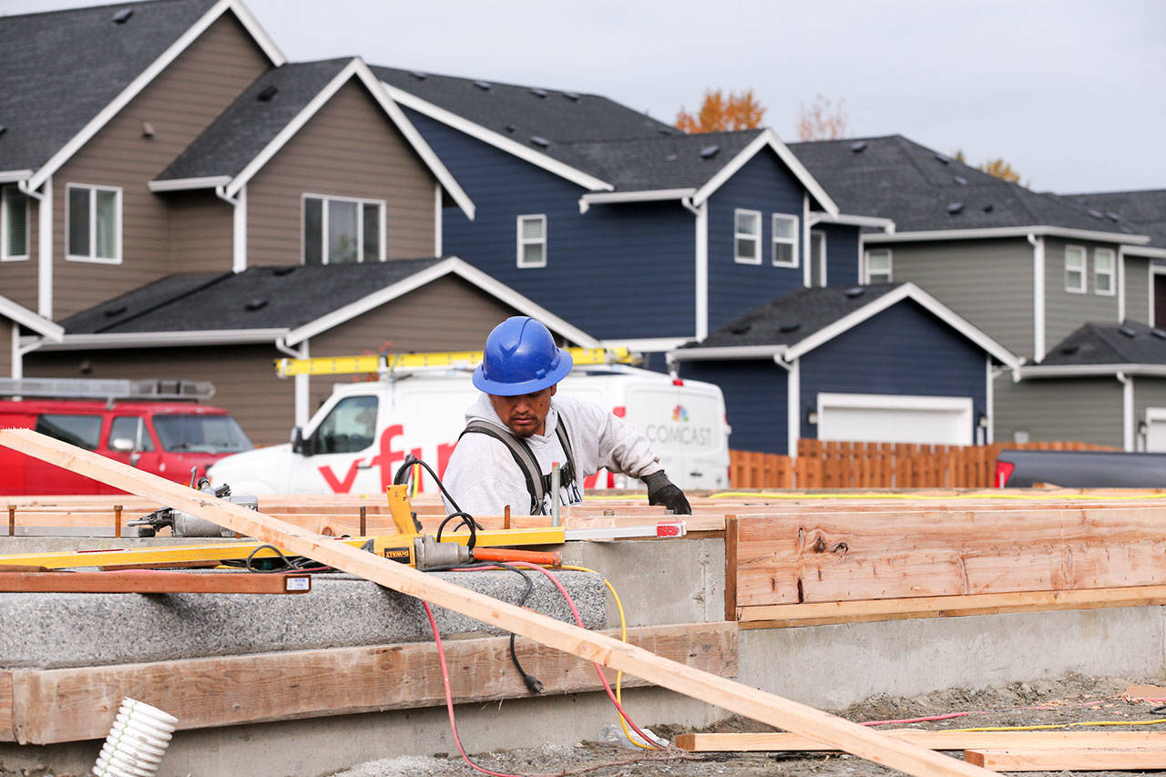 Moses Vaez frames one of the latest houses in the Overlook at Riverfront development in Everett on October 25, 2017. (Kevin Clark / The Herald)