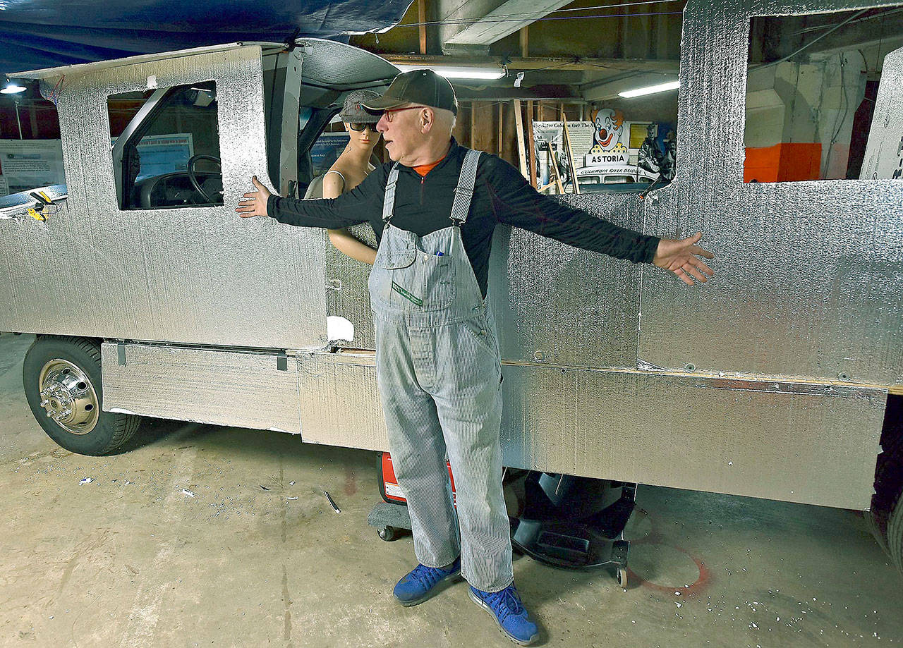 Jeff Daly stands in front of his latest automotive project Tuesday in his studio in Astoria, Oregon. Daly is remodeling an historic train he bought several years ago to travel on an old RV chassis to be used in local parades and other functions. (Colin Murphey /Daily Astorian via AP)