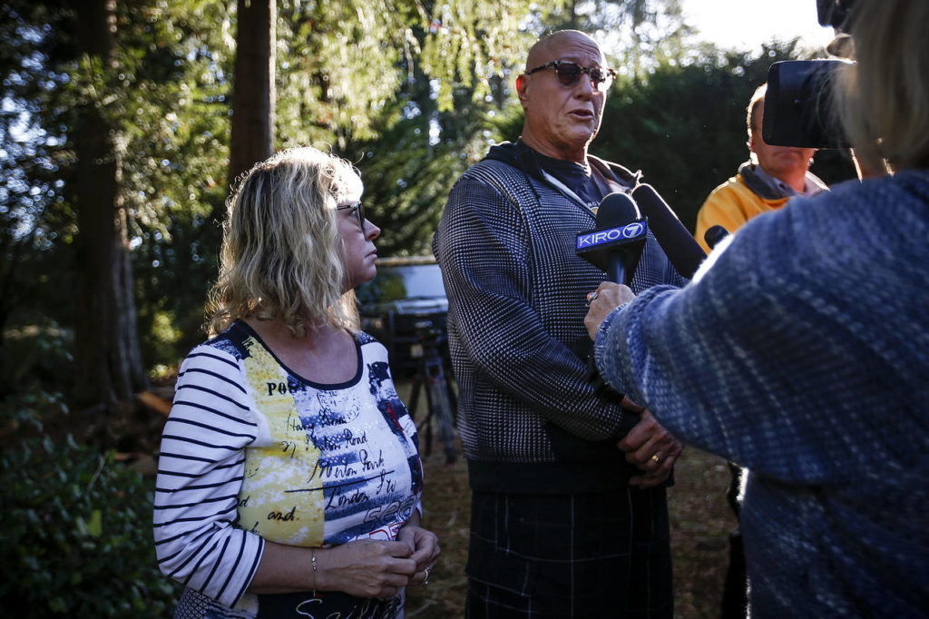 Jeffrey Abrams (center), standing next to his wife, Lillie, recounts rowing out in his dinghy to the helicopter’s wreckage minutes after it crashed into King Lake near Arlington on Tuesday. Jeffrey pulled two men from the helicopter while Lillie called 911. (Ian Terry / The Herald)
