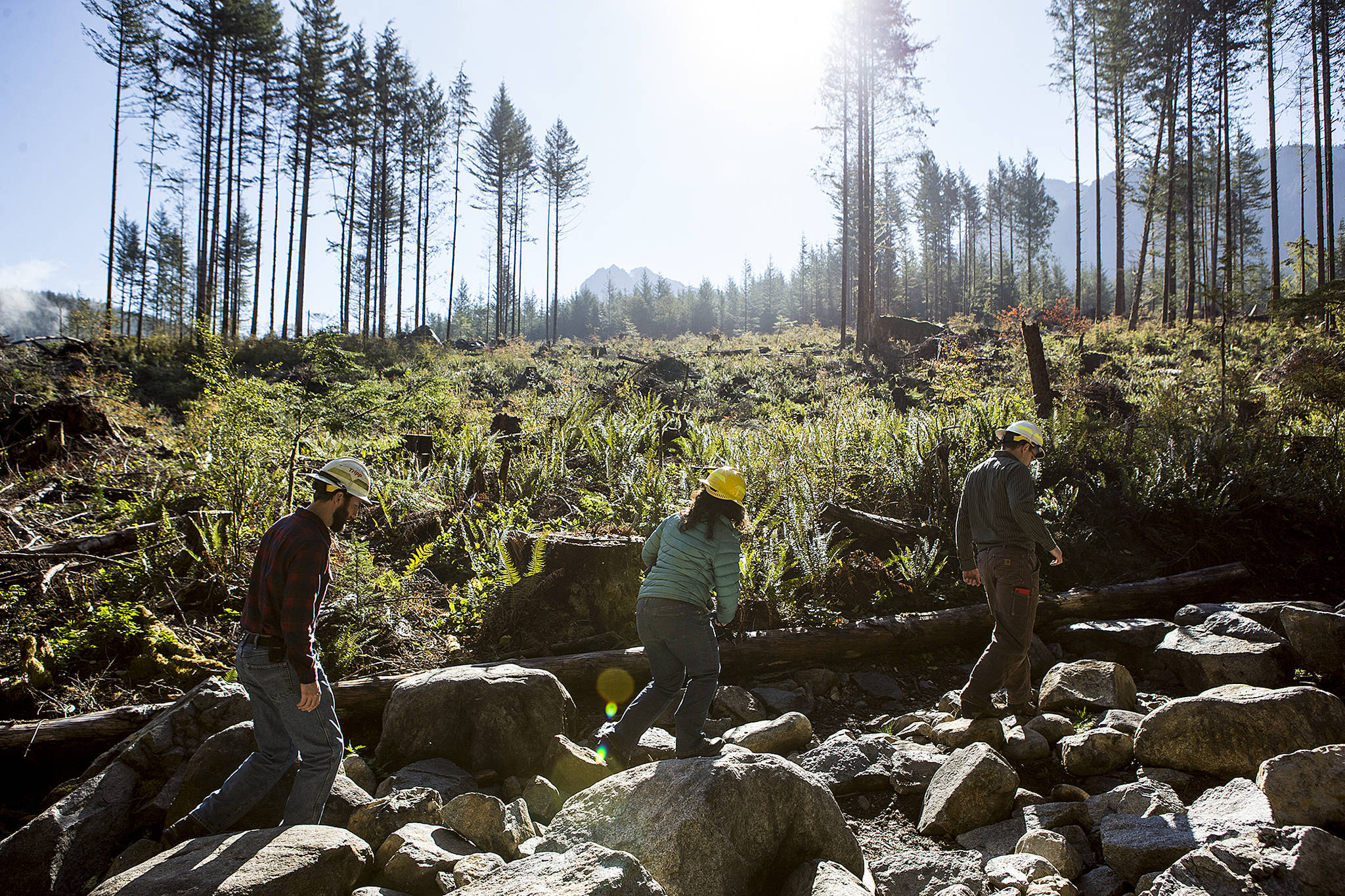 Washington State Department of Natural Resource’s John Moon (from left), Carrie McCausland and Benjamin Hale walk along a 4x4 offroad trail built as part of the Reiter Foothills Forest ORV Trails near Sultan on Thursday. (Ian Terry / The Herald)