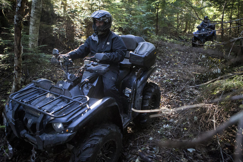 Brandon Deines (left), of Duvall, rides his ATV with Carl Teunissen, of Issaquah, at the Reiter Foothills Forest ORV Trails near Sultan on Thursday. (Ian Terry / The Herald)
