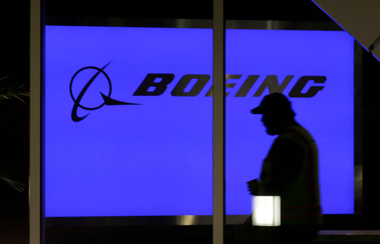 A worker walks in front of a sign at Boeing’s 737 delivery center at Boeing Field in Seattle. (AP Photo/Ted S. Warren, File)