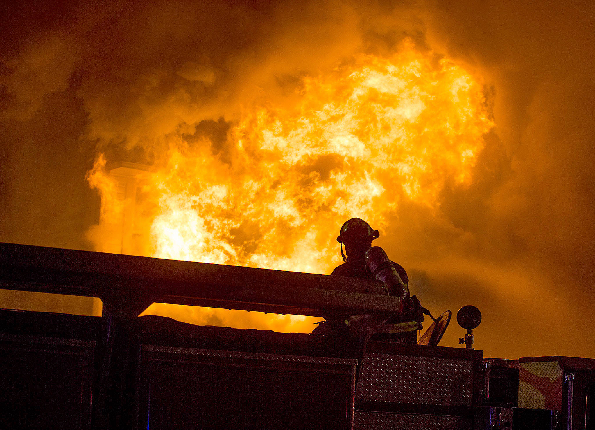 Flames burst from the front of Everett Office Furniture on Broadway in Everett on Sept. 25. (Andy Bronson / The Herald)