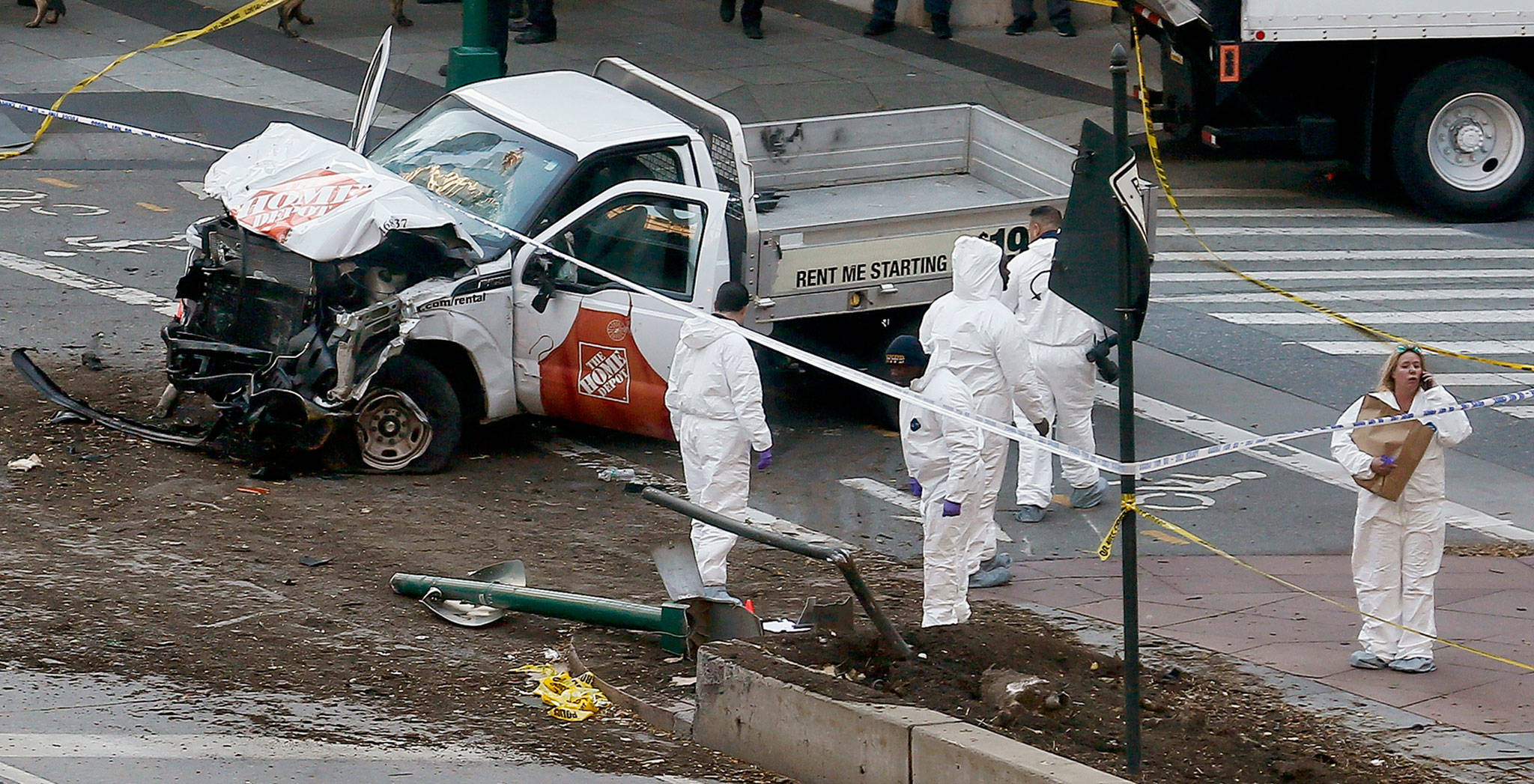 Authorities stand near a damaged Home Depot truck after its motorist drove onto a bike path near the World Trade Center memorial, striking and killing several people on Tuesday in New York. (AP Photo/Bebeto Matthews)