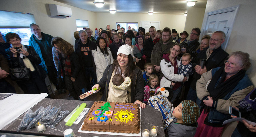 Ray and Sandy Flores accept the keys to their new home from Habitat for Humanity of Snohomish County in December 2016 in Everett. (Andy Bronson / The Herald) 
