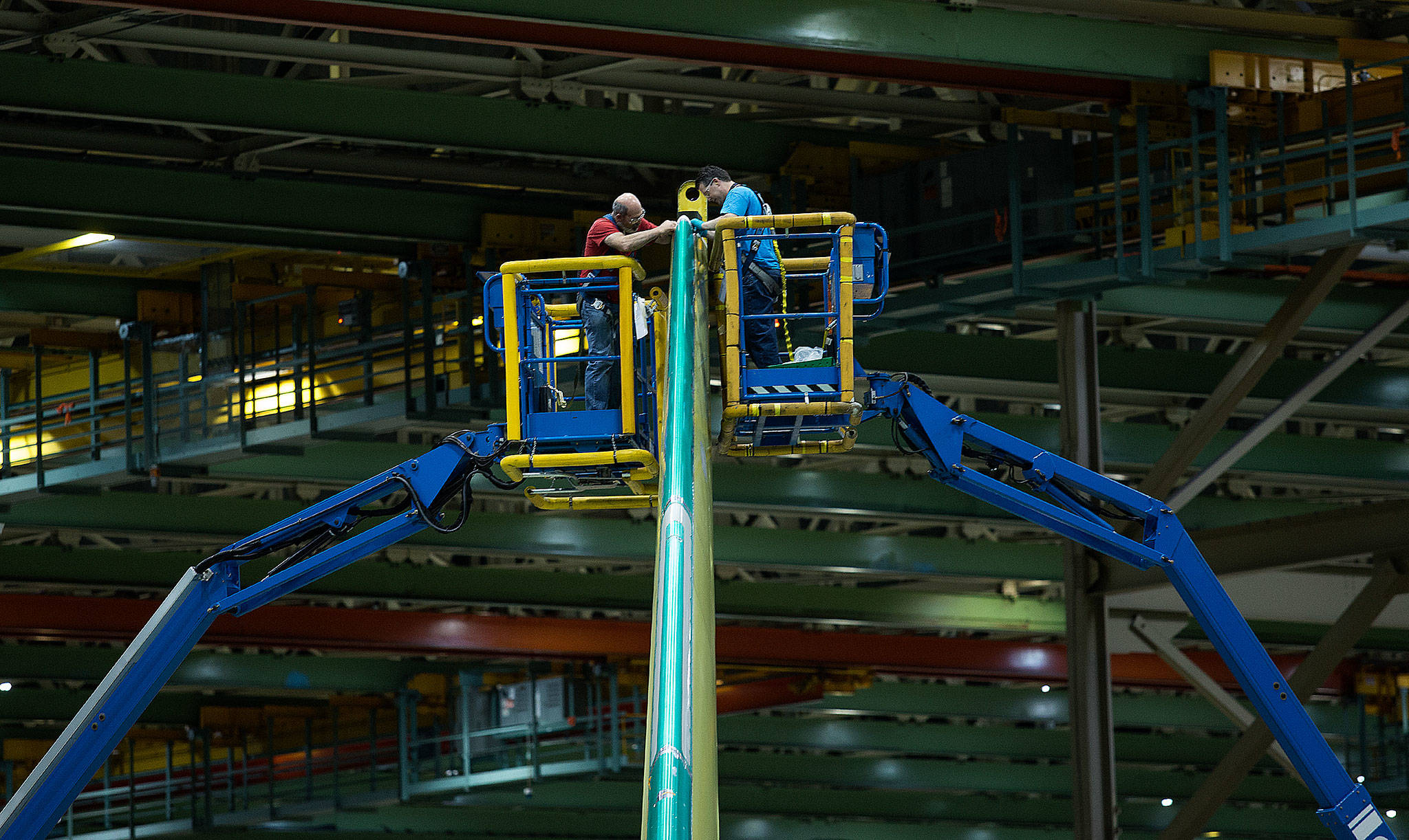 Boeing employees work on the vertical stabilizer of a 767 cargo plane in the Everett Boeing factory in May. (Andy Bronson / The Herald)