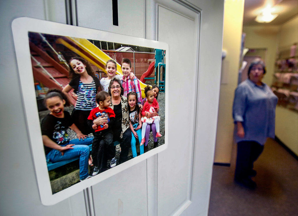 Matthew House Executive Director Linda Paz has a favorite photograph on an office door. In it, she is surrounded by children from families with incarcerated loved ones whom she has been able to serve at Matthew House. (Dan Bates / The Herald)
