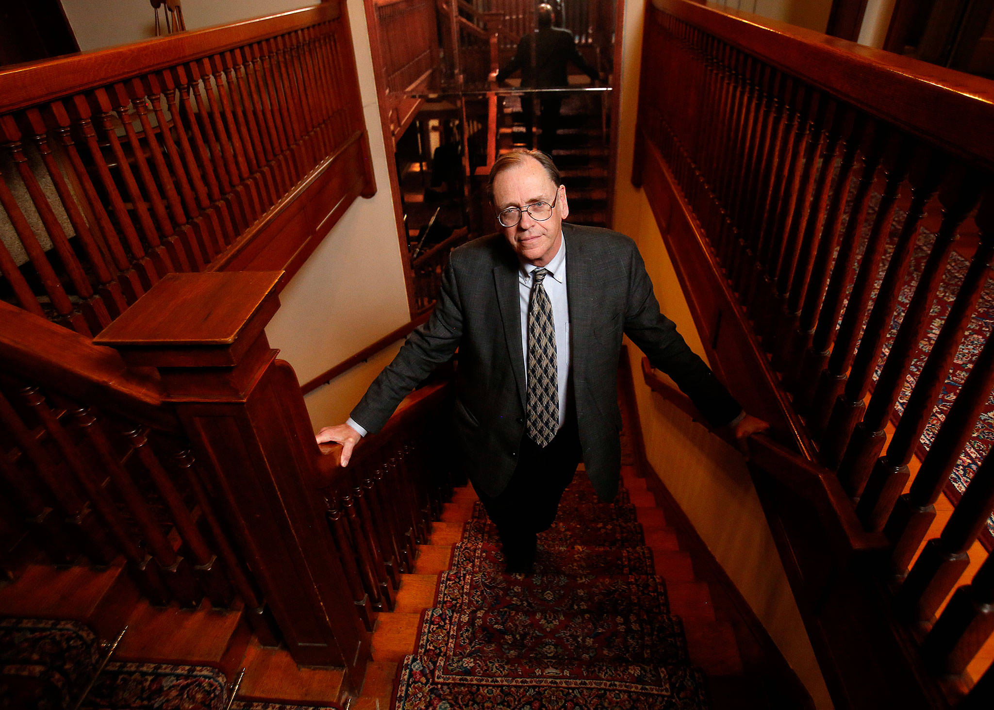 Dr. Sanford Wright climbs the staircase in Everett’s historic Hartley Mansion recently. This will be the 17th year for the Christmas Spectacular, an entertainment program spearheaded by Dr. Wright that provides a big boost to food banks and other nonprofits. (Dan Bates / The Herald)