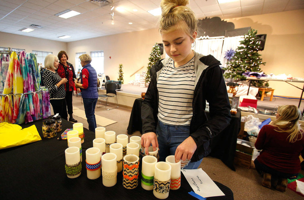 Georgia Buchanan, 13, arranges holiday items for sale on a display table for a holiday crafters’ marketplace. Buchanan belongs to Assisteens, an auxillary of the all-volunteer Assistance League of Everett. (Dan Bates / The Herald)
