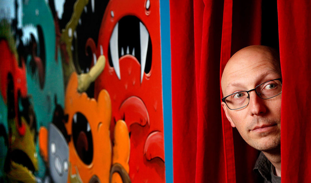 A wall in Justin Hillgrove’s studio yields to a red theater-curtain passway to another work area, as well as the artist’s imagination. (Dan Bates / The Herald)
