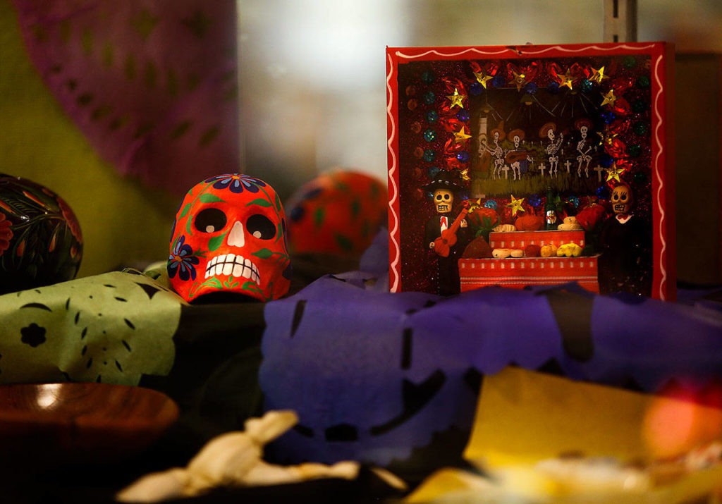 Julieta Altamirano-Crosby set up a display Tuesday about Dia de los Muertos (Day of the Dead) at the Lynnwood Library. (Dan Bates / The Herald)
