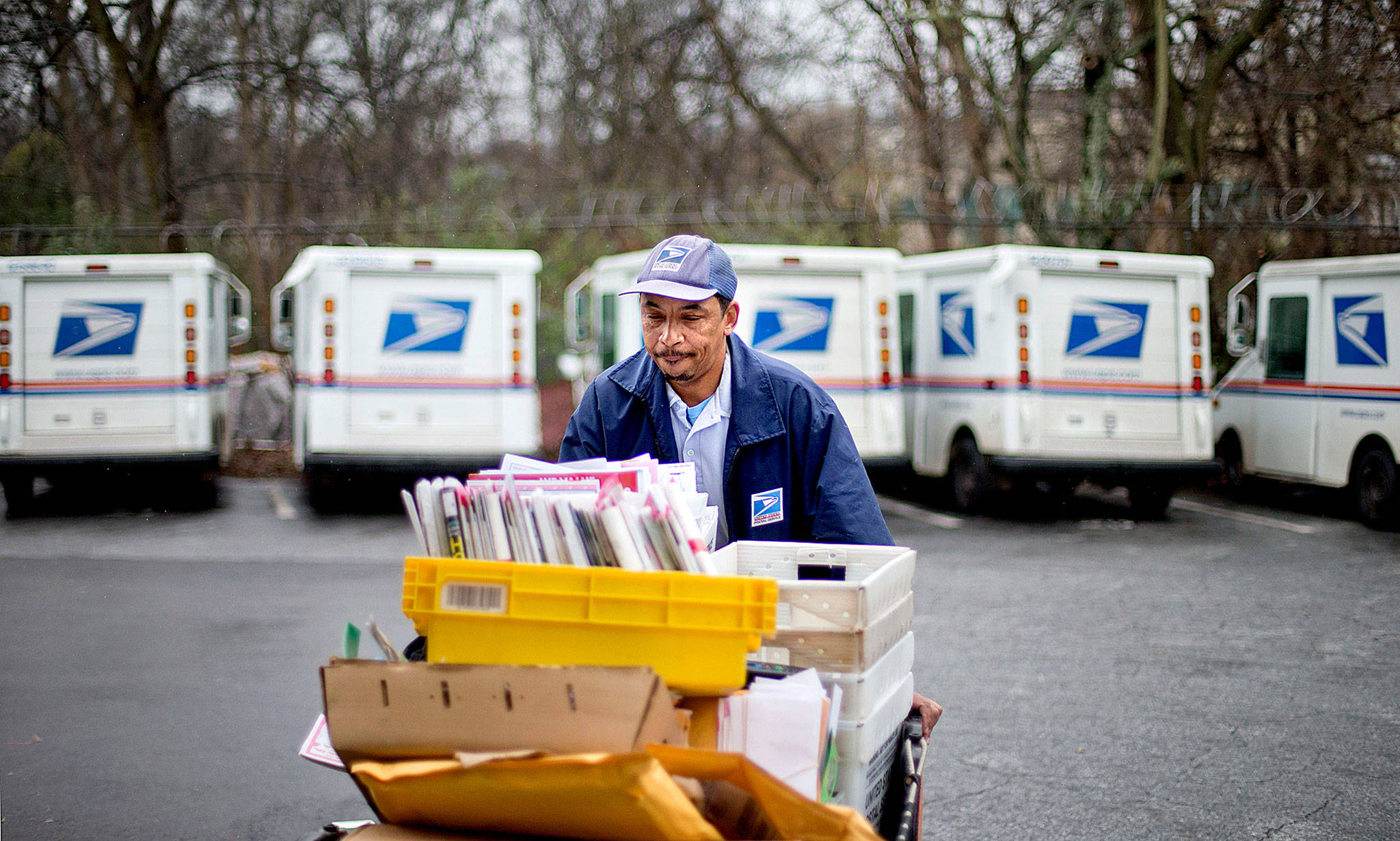 A U.S. Postal Service letter carrier gathers mail to load into his truck before making a delivery run in Atlanta. (AP Photo/David Goldman)