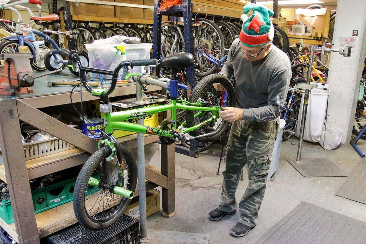 David Fox works on a bicycle at Sharing Wheels in Everett on Nov. 5. (Kevin Clark / The Herald)