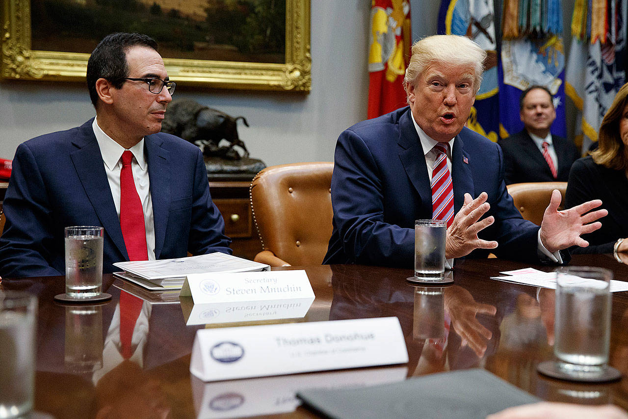 Treasury Secretary Steve Mnuchin listens as President Donald Trump speaks during a meeting on tax policy with business leaders in the White House on Tuesday. (AP Photo/Evan Vucci)