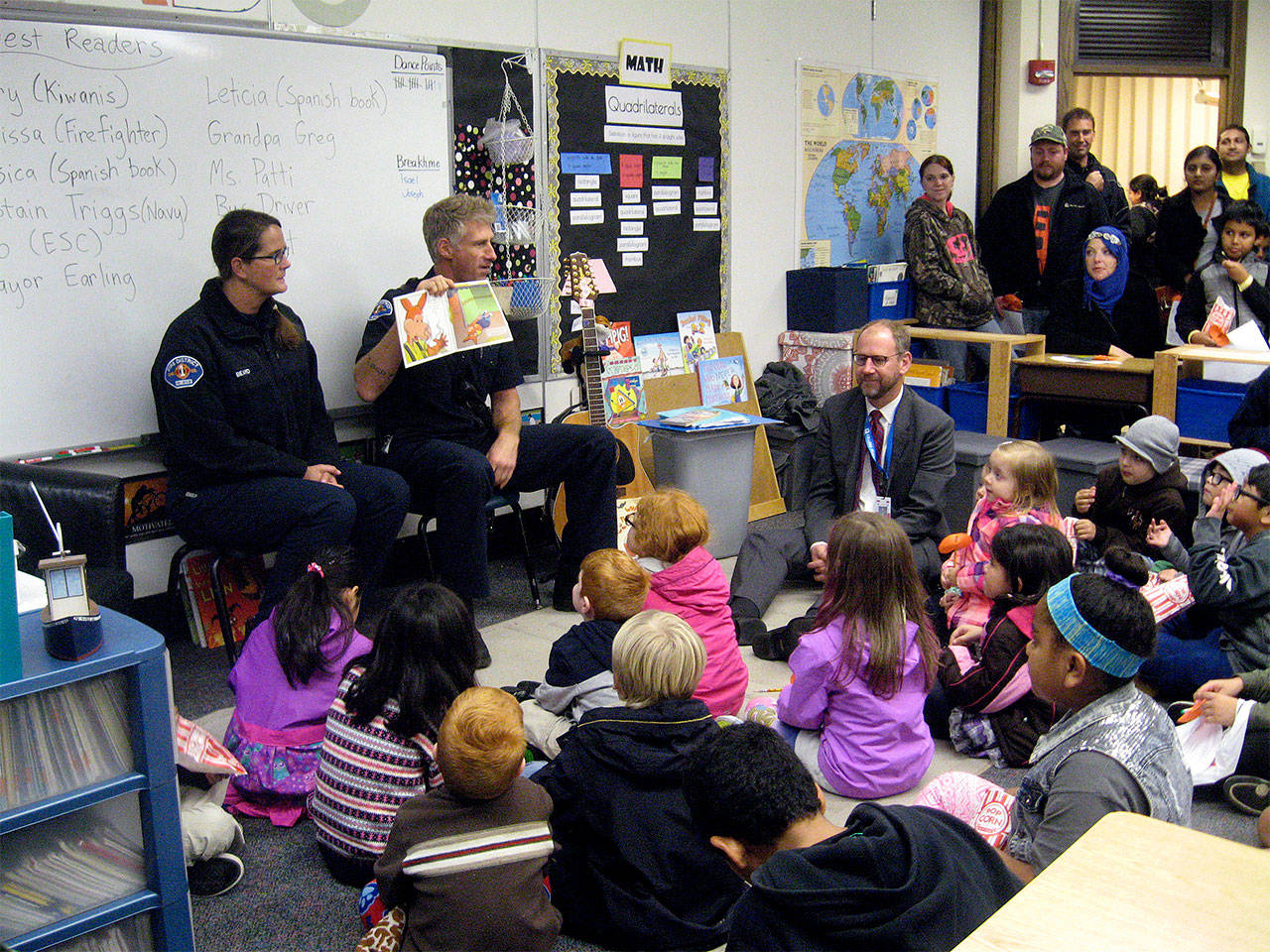 Edmonds firefighters read to families at a Falling in Love with Reading event, held Oct. 19 at College Place Elementary School. (Contributed photo)